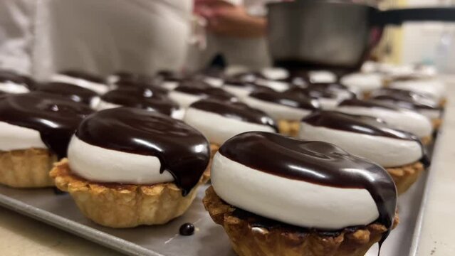 Close-up view of the make-of traditional homemade chocolate and meringe cakes.