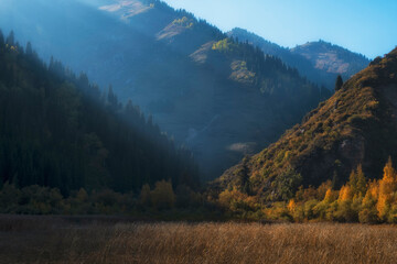 Mountain range at sunset in autumn with haze. Ridge Zailiysky Alatau in Tien Shan system