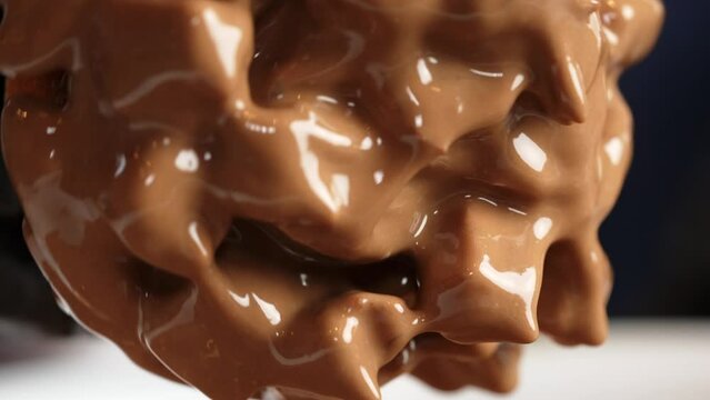 Cholotae ferrero donut being decorated dipped in cholocate dripping close up