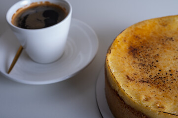 cheese cheesecake with a crust, cut into a piece, on a light dish, background. Cooking cakes, pastries