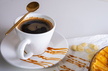 top view, a cup of coffee on a light background, a close-up view in a light dish. Place for...