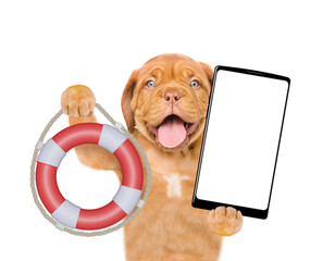 Happy mastiff puppy shows lifebuoy and holds big smartphone with white blank screen in it paw. Isolated on white background - obrazy, fototapety, plakaty