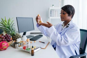 Portrait of nutrition specialist or dieting expert wearing lab coat and stethoscope looking at...