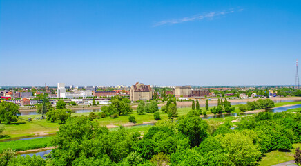 Fototapeta na wymiar Magdeburg, Germany. Panoramic bird view over the Elbauen city park, Elbe river and old industrial harbor. Cityscape in the historical downtown in Magdeburg at sunny day and blue sky.