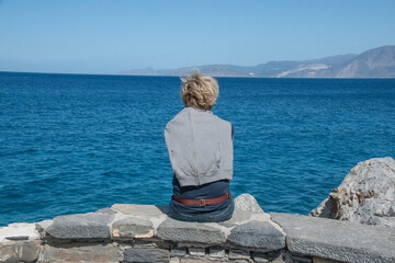 Femme de dos admirant la vue sur la mer en Crète