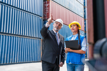 Container yard manager with safety hat talking to foreman about the goods inside the warehouse, Logistics business, Import and export concept.