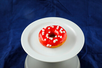 Strawberry Glazed Donut served in plate isolated on blue background side view of baked food breakfast on table