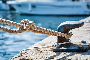 Thick rope securely fastened to a berth on the pier, concept for secure cohesion