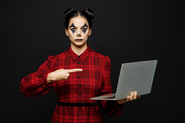 Young IT woman with Halloween makeup face art mask wear clown costume red dress work hold use point...