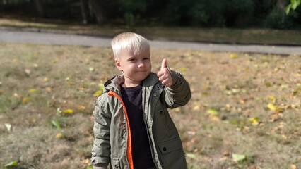 cute funny boy child blond on the street in the park