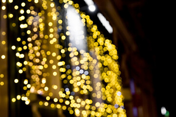 Defocused blurred shop windows decorated with with christmas lights garland during winter holidays