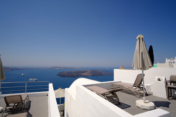Apartment balcony in a white luxurious resort with great views of the Santorini Island shore Mediterranean Sea - obrazy, fototapety, plakaty