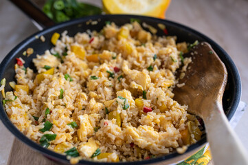 Zucchini rice with peppers, onions and chives in a frying pan