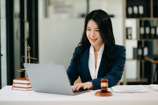 Asian lawyer woman working with a laptop and tablet in a law office. Legal and legal service concept.