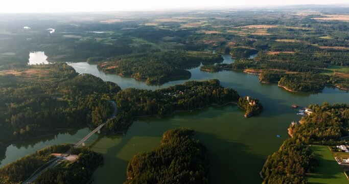 Aerial overview of Stausee Ottenstein reservoir as sunlight reflects across winding water tendrils