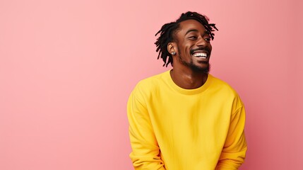 Smiling man in yellow with joyful expression on pink background.