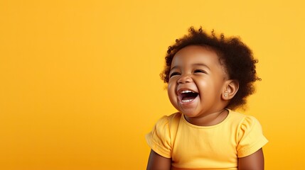 Delighted baby laughing in yellow on orange background. - obrazy, fototapety, plakaty