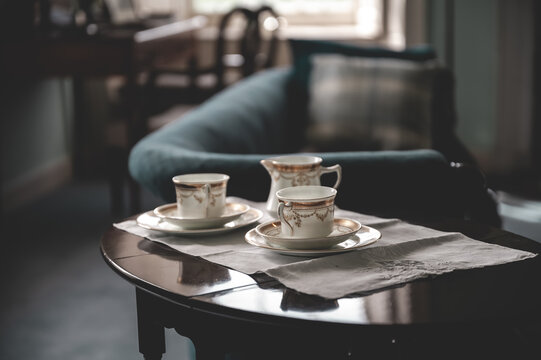 Tea cups on a old wooden table with couch indoors at Skaill House, Orkney Island, Scotland