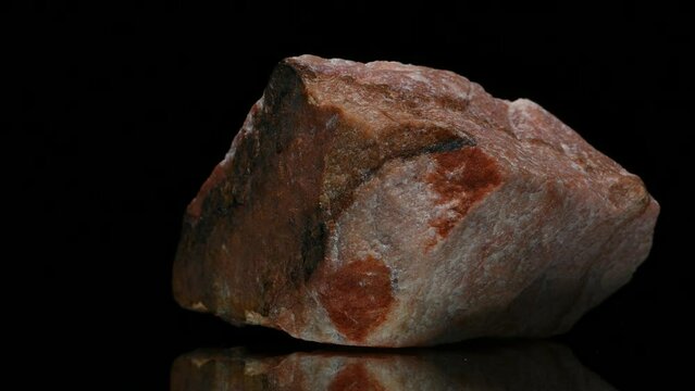 Sunstone (oligoclase feldspar with hematite inclusions) specimen rotating slowly against a black background.