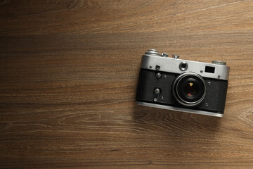 Vintage camera on wooden background, space for text