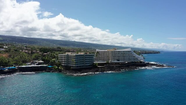 Low panning aerial shot of the Royal Kona resort along the coast of Kailua-Kona in Hawai'i. 4K