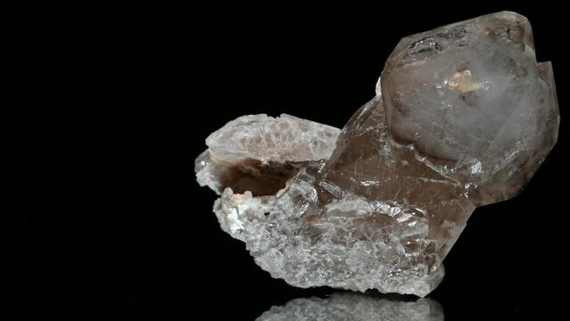 Stilbite crystals [hydrated sodium calcium aluminosilicate] specimen rotating slowly against a black background.