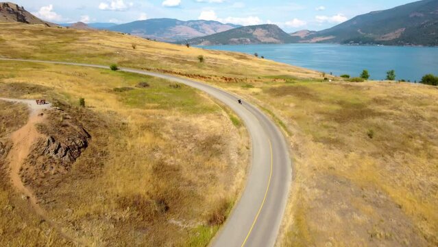 Riding a Harley Davidson Chopper Motorcycle, on a Road Trip Joyride, Along Scenic Route with Lake View. Winding Corners, Blue Skies and Open Roads. Vernon, British Columbia, Canada. 1 of 12