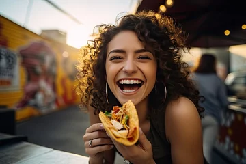 Foto op Aluminium Portrait of young mexican woman eating a taco on a restaurant © PapatoniC