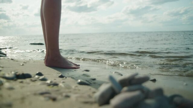 Barefoot women stand by the sea on a sunny day, Sandvik, Öland Sweden , close up wide