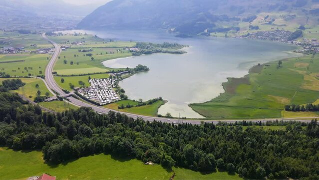 panoramic aerial view of idyllic magical Swiss lake and alpine villages in Switzerland featuring Lauerzersee, Lauerz Village, Scenic Highway, Swiss Meadows in Steinen in Schwyz 