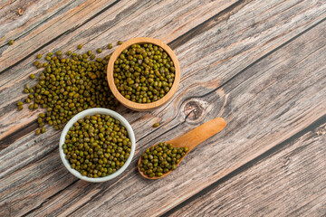 Mung beans isolated on spoon and cup wooden on wooden background