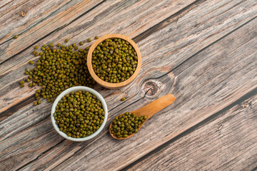 Mung beans isolated on spoon and cup wooden on wooden background