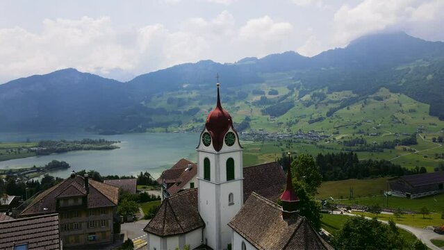 panoramic aerial view of idyllic magical Swiss lake and alpine villages in Switzerland featuring Lauerzersee, Lauerz Village, Baroque Church Kirche St. Anna in Steinerberg, Swiss Meadows in Schwyz 
