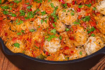 Stewed rice meatballs in deep frying pan, fragment close-up