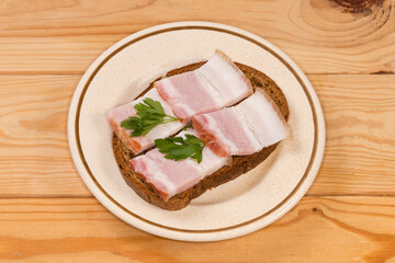 Open sandwich with boiled-smoked pork belly slices on saucer