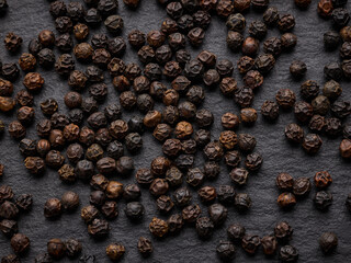 Black pepper texture over black stone surface