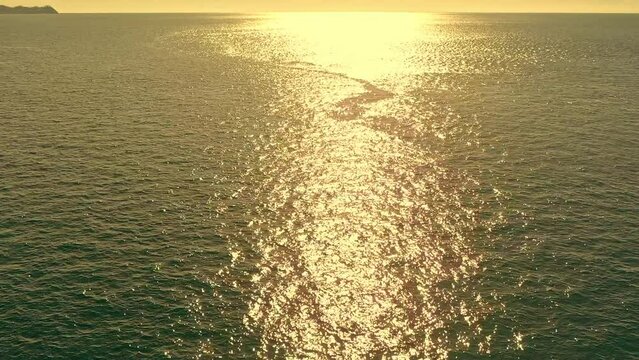 Aerial View Over the Ocean with Sunlit Reflection in Warm Light in the Philippines.