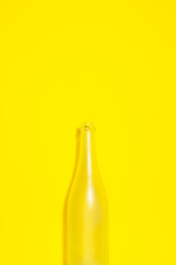 Empty champagne bottle on yellow background