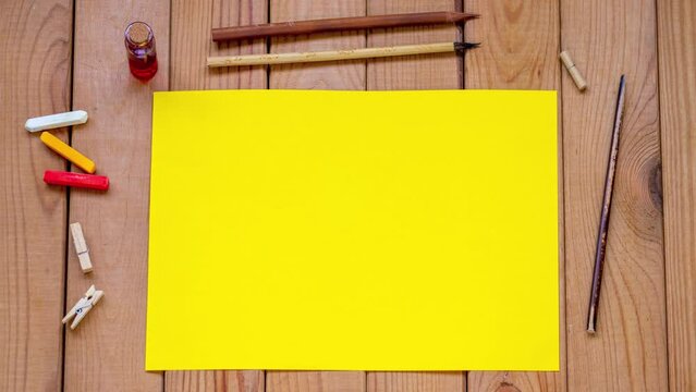 yellow paper on wooden background, stop motion