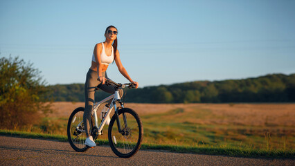 Brunette fit woman in sportswear with bicycle