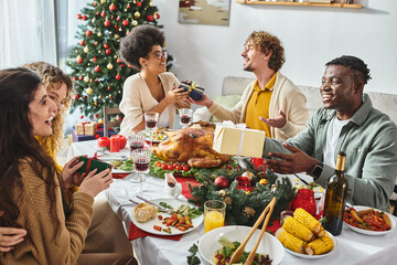 big cheerful and multiracial family having great time celebrating Christmas and exchanging gifts