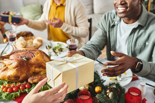 cropped view of cheerful african american man receiving gift from his relative, Christmas day