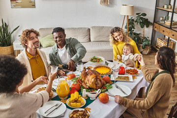 african american man pouring wine into glass of female relative, multiethnic friends and family