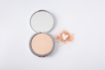 Beautiful eyeshadow palette on white with crushed sample heart shape. Makeup product