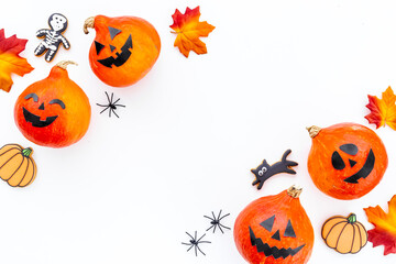 Flat lay of orange Halloween pumpkins and dry leaves, top view