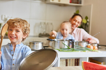 Happy boy having fun with family in kitchen at home