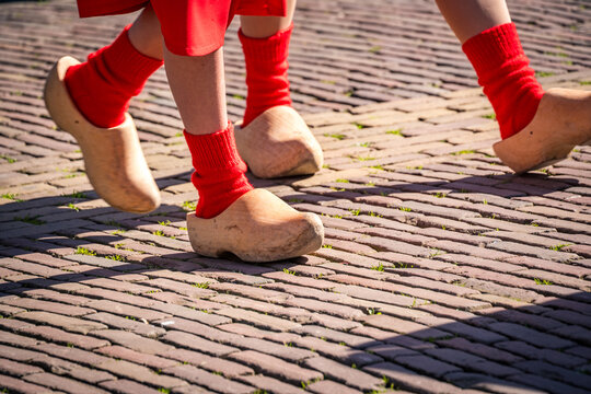 dutch women walking in traditional wooden shoes at alkmaar cheese market