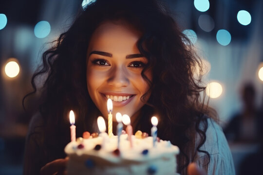 A beautiful young woman blows out the candles on her birthday cake.	