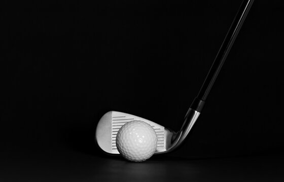 Golf Club Iron and Ball pictured on a Black Background with Surface Showing, Studio Shot with Copy Space