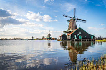 traditional dutch windmills reflecting in lake at zaanse schans